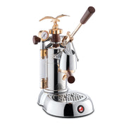 La Pavoni Expo 2015 coffee machine featuring a polished chrome body with copper eagle finial, manual lever, pressure gauge, wooden handles, and drip tray. Professional-grade espresso maker with vintage-inspired design elements and modern functionality.